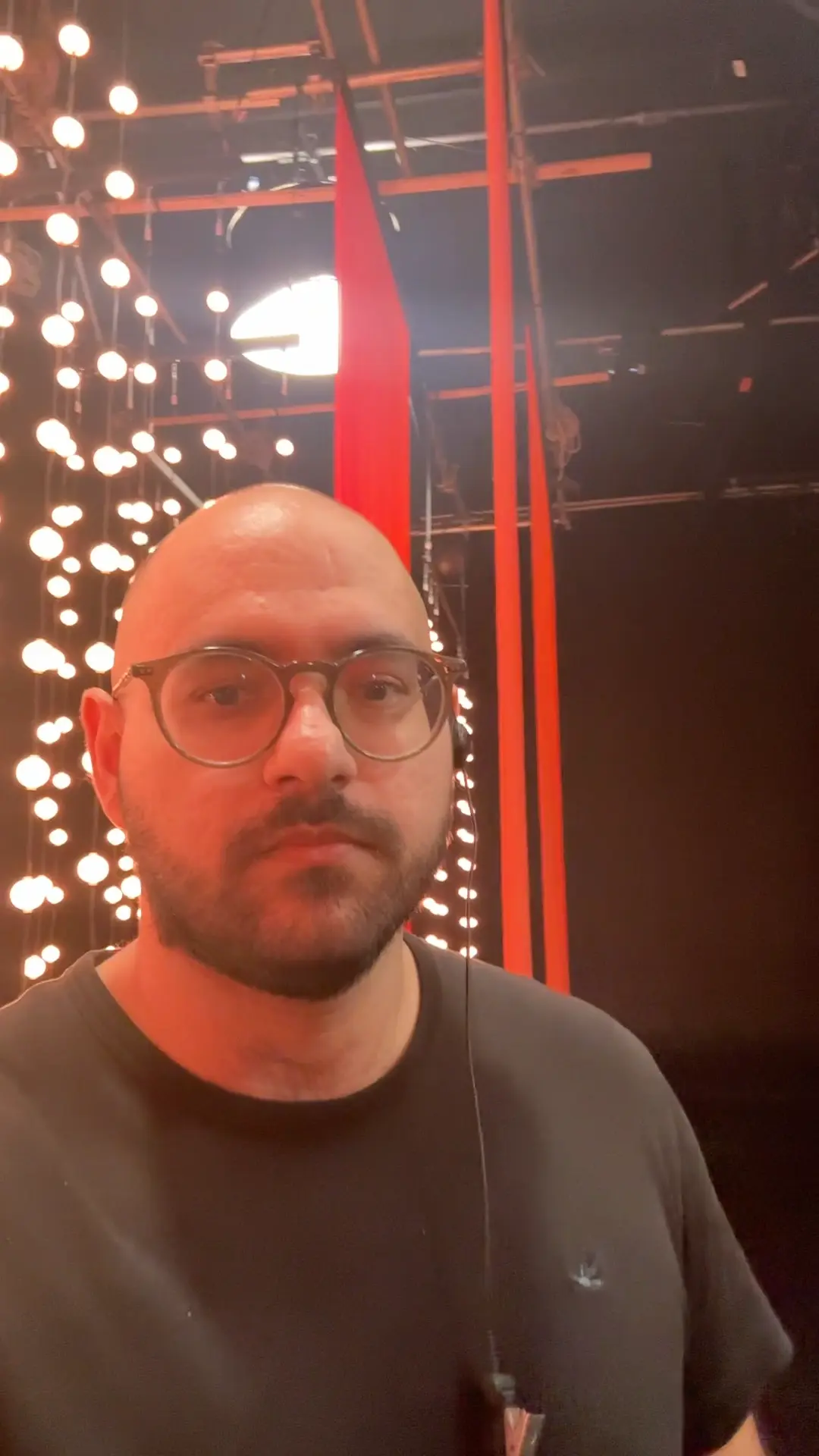 Nicolai em set com luzes vermelhas ao fundo
